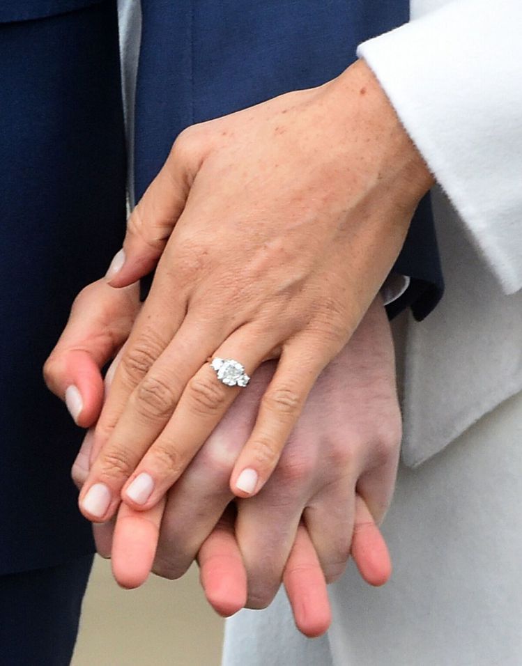 梅根的訂婚戒指由哈利王子親手設計，主鑽旁的兩顆鑽石取自黛安娜王妃擁有的珠寶，象徵「母親永遠陪在左右」。(歐新社)