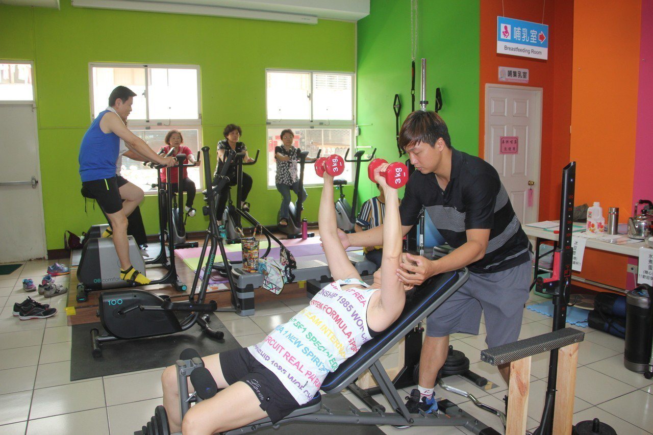 健身房專業教練指導民眾如何做運動，訓練肌力、長肌肉。