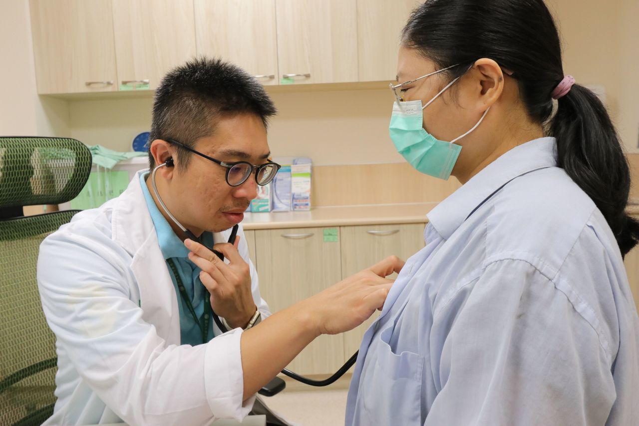 亞大醫院心臟血管外科主任劉殷佐（左）聽診，了解病患術後復原狀況。圖／亞大醫院提供