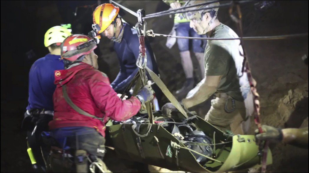 泰國救難人員11日把一名受困少年放到擔架上抬出洞。 美聯社