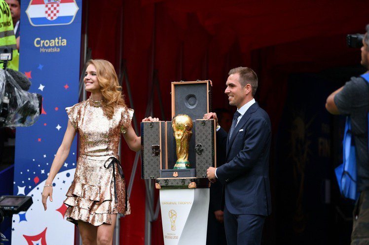 娜塔莉亞．沃迪亞諾娃身穿金色路易威登刺繡洋裝，護送世界盃獎座及路易威登訂製手提硬...