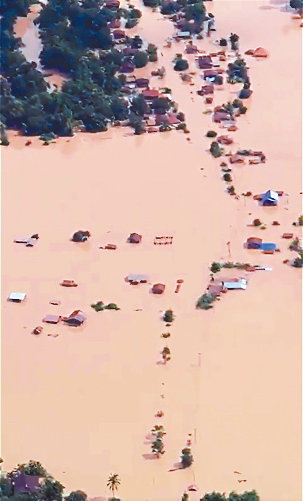 廿四日的空拍畫面顯示，潰堤的寮國水壩下游地區許多房屋泡在黃濁洪水裡。 （法新社）