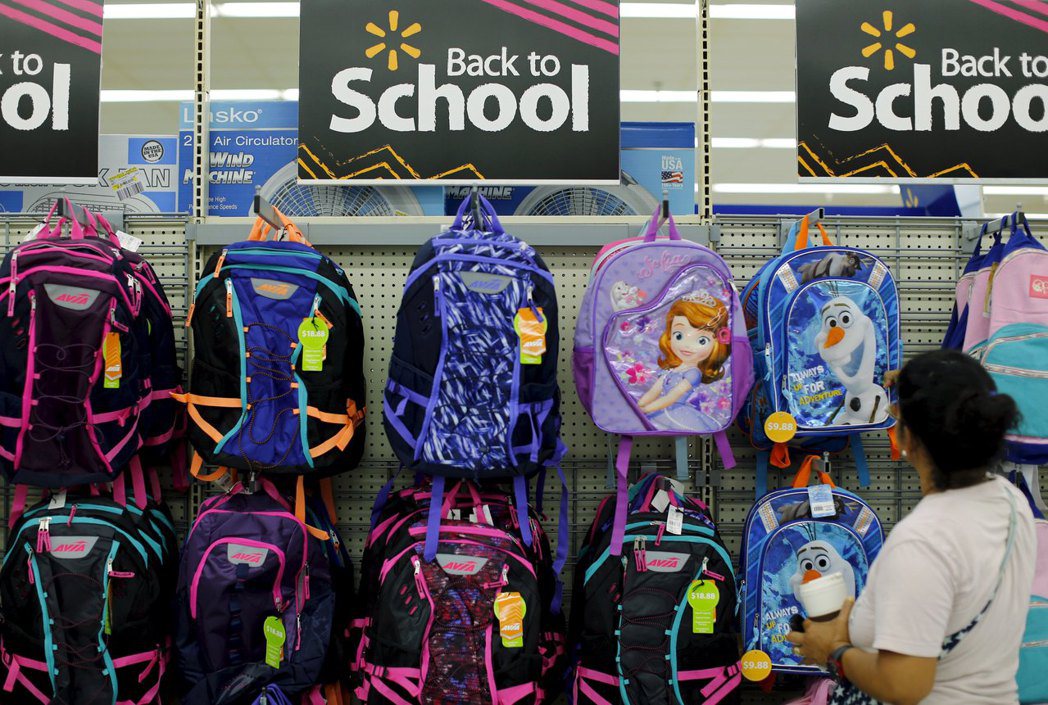 每年8月的開學季時，美國家長就忙著為子女採購上學用品，圖為一名婦女在賣場幫孩子挑...