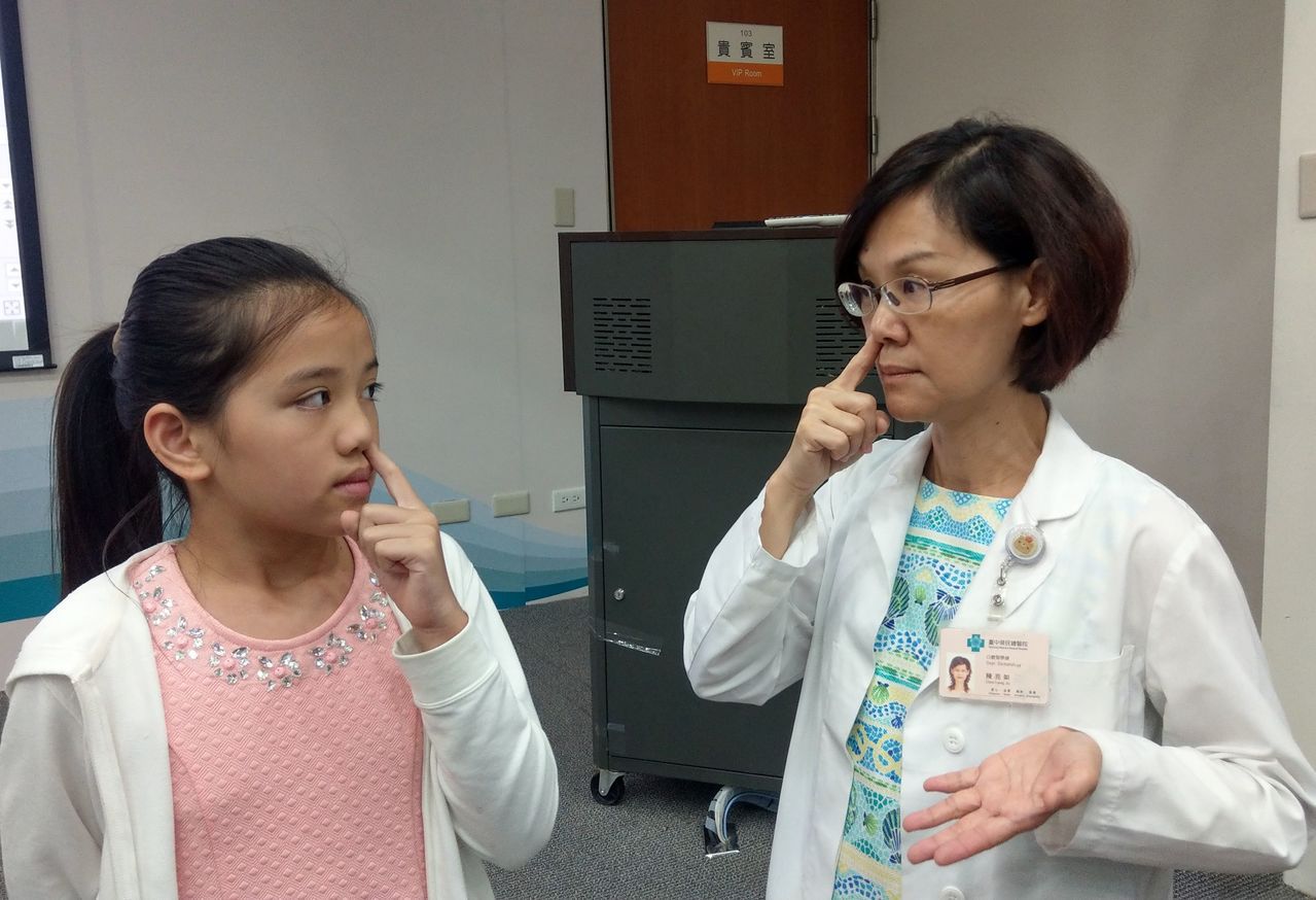 醫師陳亮如（右）教導許姓女童（左）鼻呼吸方式，即閉上嘴巴後，按住單側鼻孔，吸飽氣後閉氣，改按另一側鼻孔吐氣，再左右互換，連續做5循環。