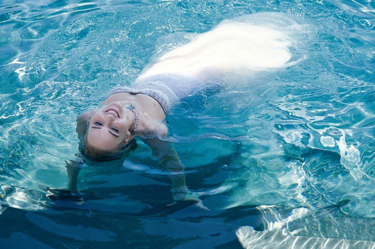珍妮佛勞倫斯為JOY by Dior香氛拍攝廣告，身穿紗裙在水中輕舞的唯美姿態宛...