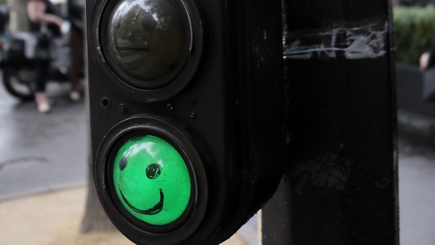 巴黎街頭上的紅綠燈，綠燈上有笑臉圖案表示可通行。 （法新社）