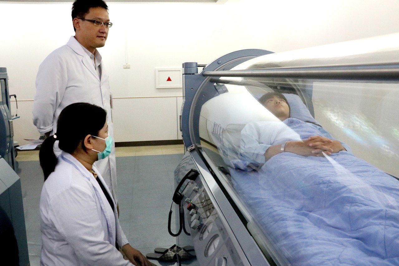 羅東博愛醫院復健醫學科醫師何春生(左)為兩生安排高壓氧治療，有效修補受傷細胞。圖／羅東博愛醫院提供