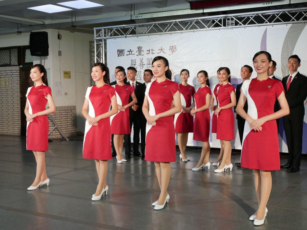 台北大學親善團展示今年服裝，男生著黑色西裝與紅色領帶，女生連身洋裝以雁型線條領口...