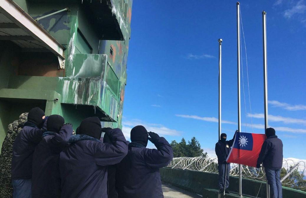 小雪山雷達站官兵升旗，可看到牆壁上有殘霜。 圖／引自海軍臉書網頁