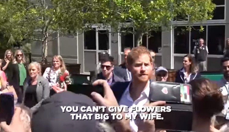 民眾送上超大把的花束給梅根，哈利故作吃醋警告對方。圖／摘自Youtube