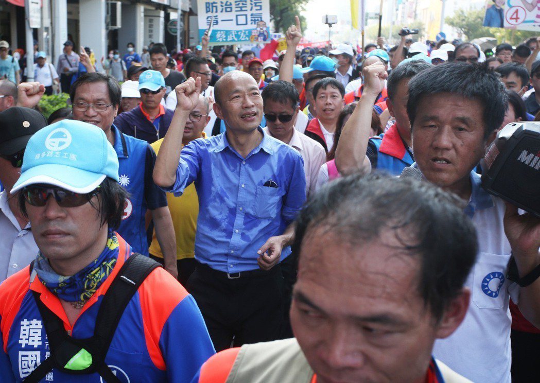 國民黨高雄市長候選人韓國瑜（中）與遊行民眾一起高呼反空汙口號，旁邊的支持者則高喊...
