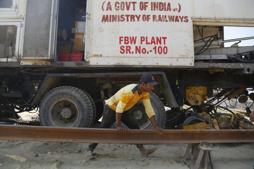 印度出資幫蓋鐵路，圖為尼泊爾工人正在搭建鐵路軌道。 （美聯社）
