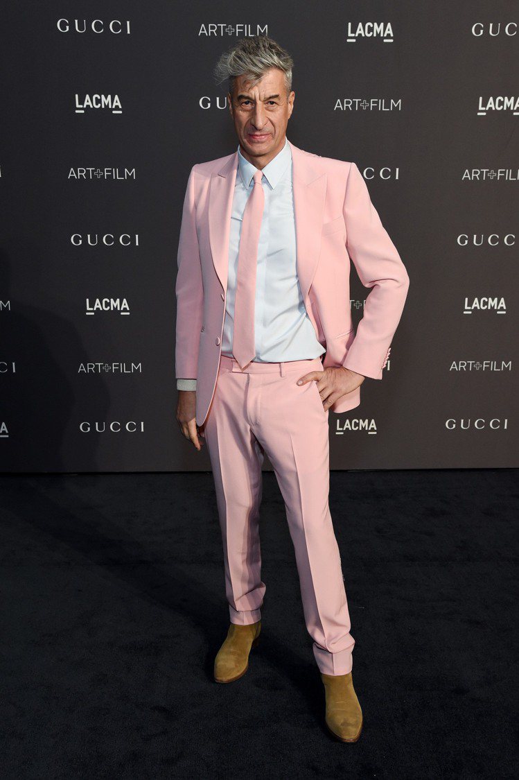 藝術家莫瑞吉奧卡特蘭穿著Gucci訂製粉紅色Heritage西裝搭配淺藍色絲質襯...