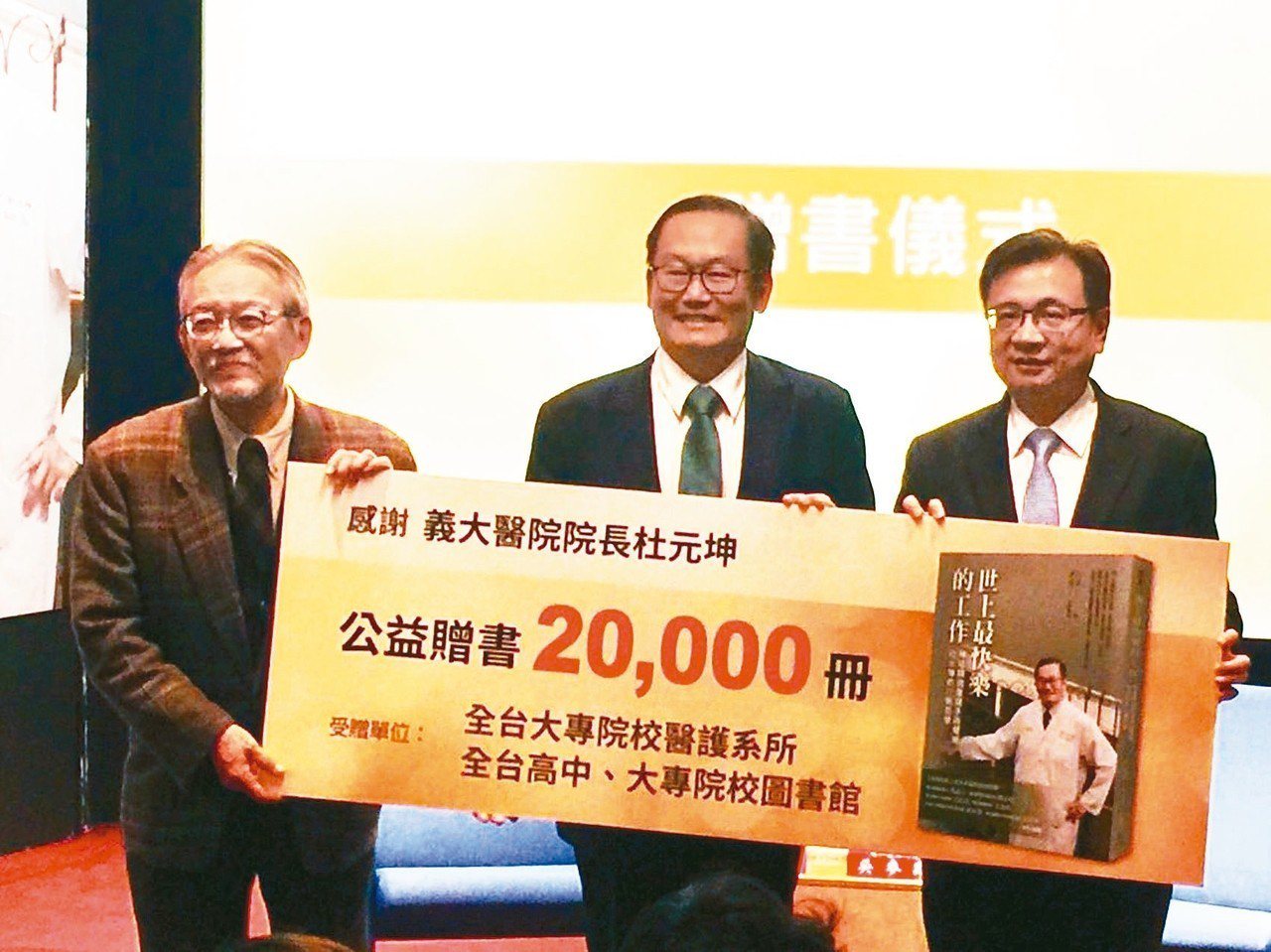 義大醫院院長杜元坤(中)昨捐贈2萬本新書「世上最快樂工作」給母校台北醫學大學。