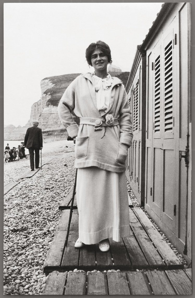 在腰間配戴山茶花的香奈兒女士於埃特雷塔(Étretat)海灘，約 1913年。圖／香奈兒提供