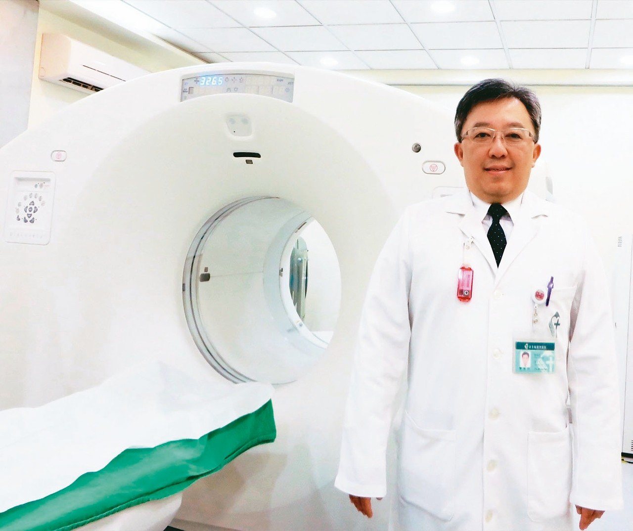新店耕莘醫院醫務部副主任兼核子醫學科主任樊裕明與正子斷層造影掃描儀。