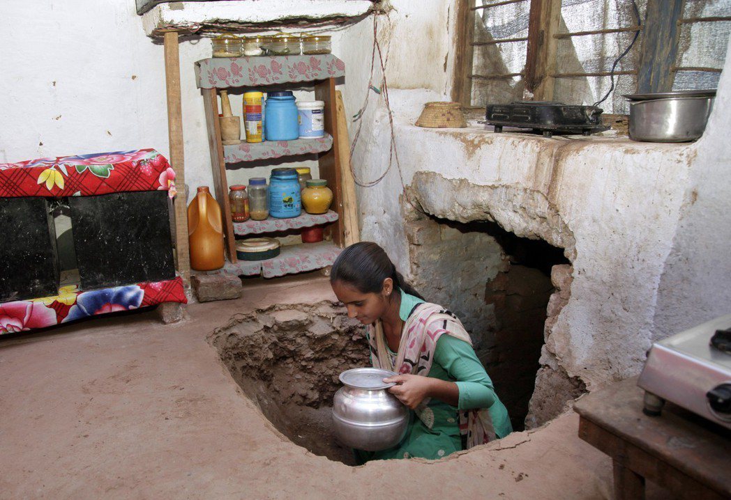 印屬喀什米爾一名婦女拿著飲用水，從家中地下掩體走出來。（美聯社）