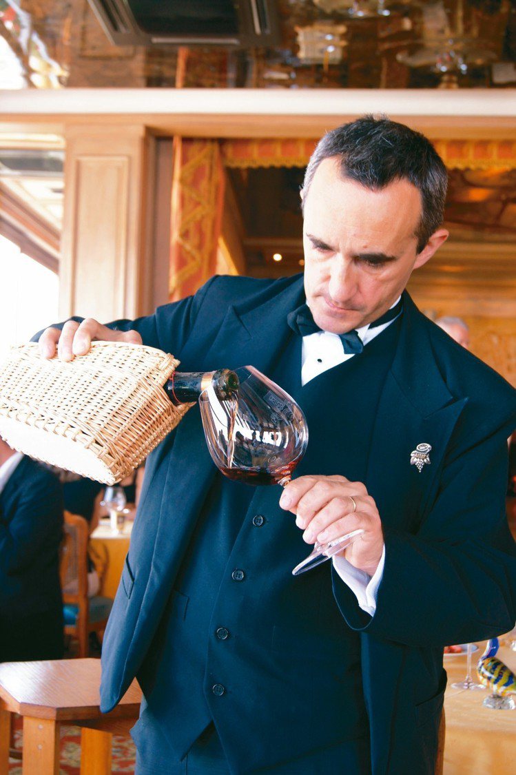 Stephane Trapier，知名的銀塔餐廳侍酒師。他手上正在斟的是一支1905年的布根地百年老酒。圖／謝忠道  ※ 提醒您：禁止酒駕 飲酒過量有礙健康  