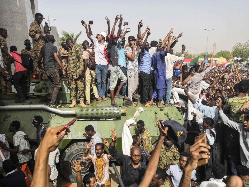 蘇丹示威者11日在首都喀土木登上軍車，慶祝總統巴席爾遭罷黜。（法新社）