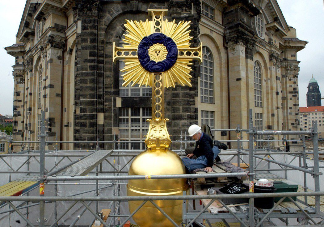 德勒斯登聖母教堂頂端的金色十字架，仿18世紀建造，純手工打造。工匠的父親，當年是...