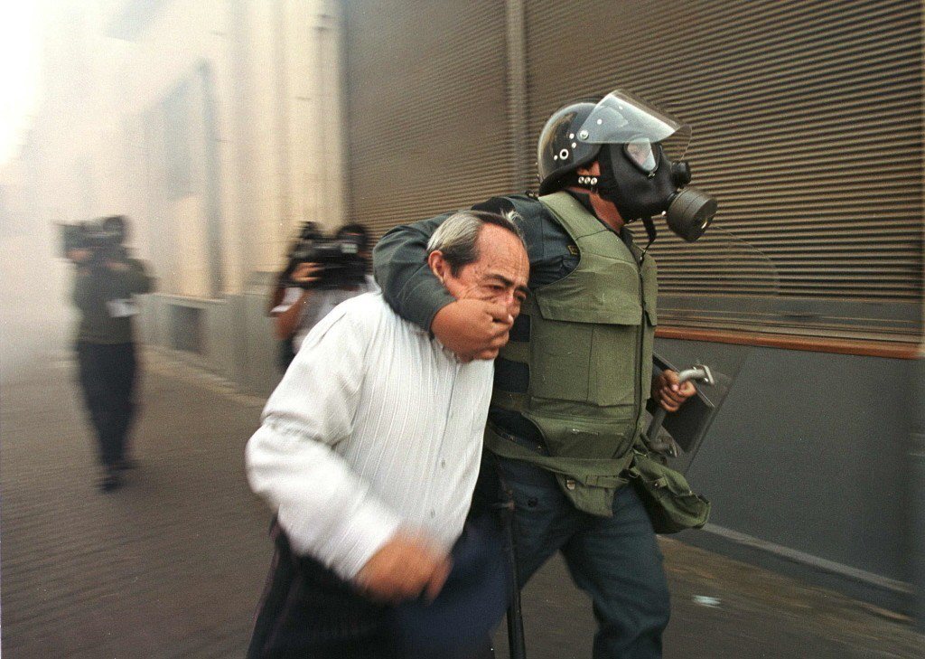 搞定警察可以鎮壓反對黨抗議，同時容忍挺政府惡徒的暴力行為。圖為一名秘魯示威者抗議藤森獨裁。 圖／美聯社