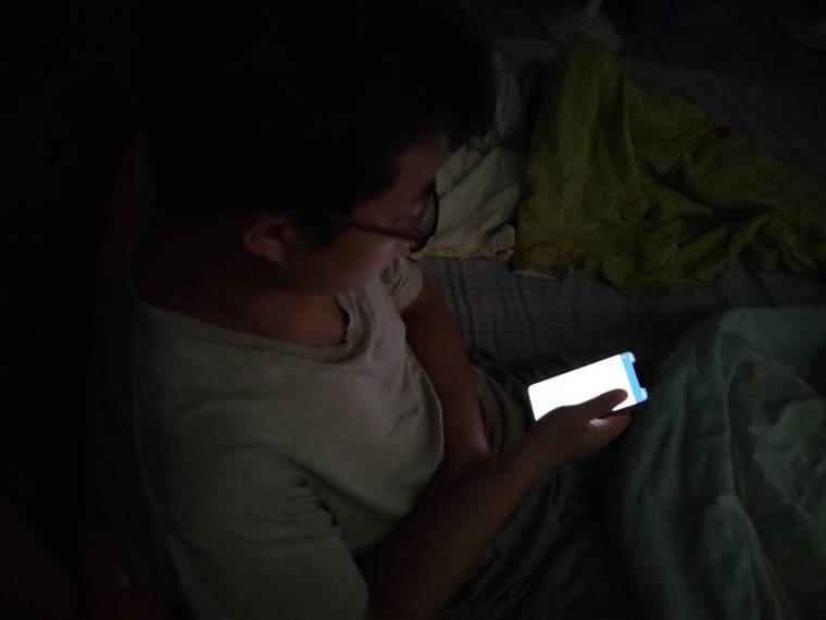 手機藍光會抑制褪黑激素分泌，醫師建議睡前避免滑手機以免影響睡眠品質。圖/台南市立...