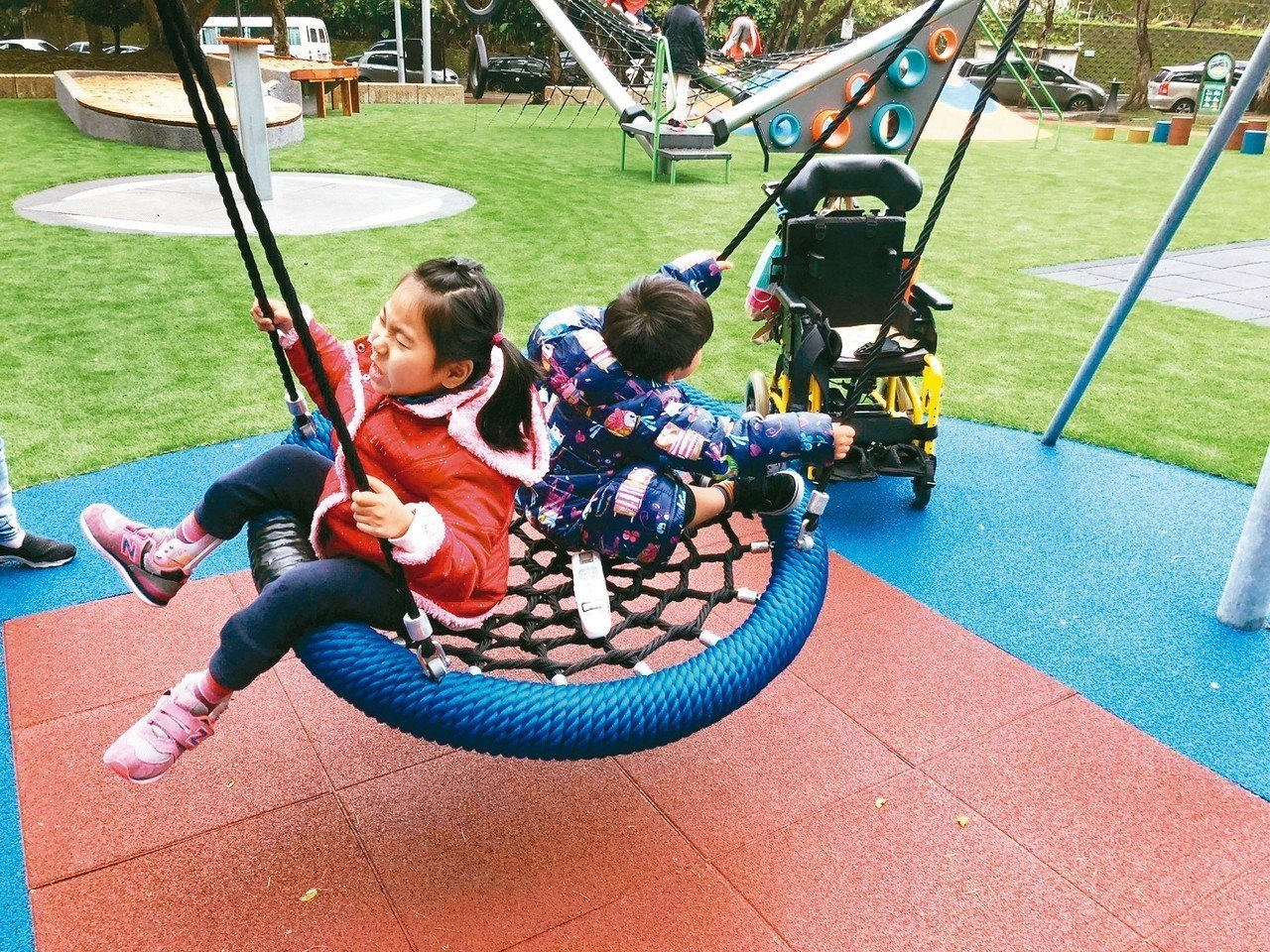 鄭淑娟聯合許多家長推動共融遊戲場，讓有身心障礙的黃澄寗（左）可以與弟弟黃睦恆一起玩。