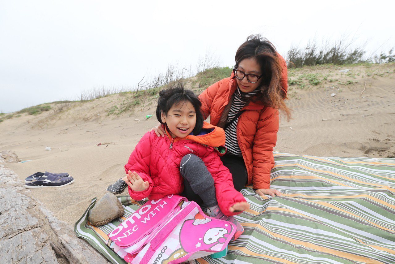 黃澄寗（左）與母親鄭淑娟看海，海風吹拂在澄寗的臉上，她展露笑容。

記者許正宏／攝影