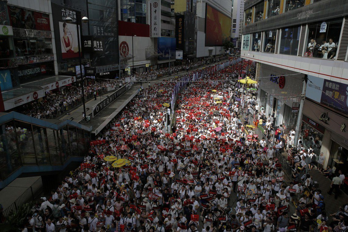 圖為9日香港「反送中」遊行，身穿白衣的群眾，從各區緩步湧入金鐘的香港特區政府總部...
