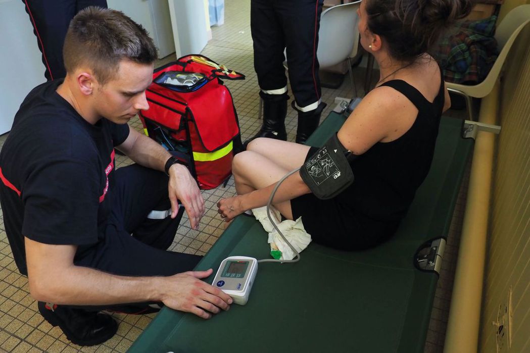 法國中部土爾市的醫護人員幫一名出現中暑症狀的婦女量血壓。 （法新社）