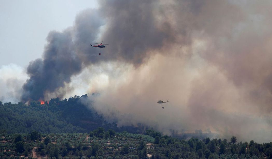 西班牙加泰隆尼亞山區森林27日熱到發生火災，直升機趕往救火。 （路透）