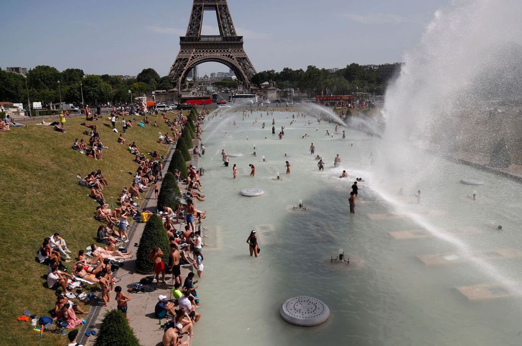 民眾在巴黎艾菲爾鐵塔附近的水池戲水。 （法新社）