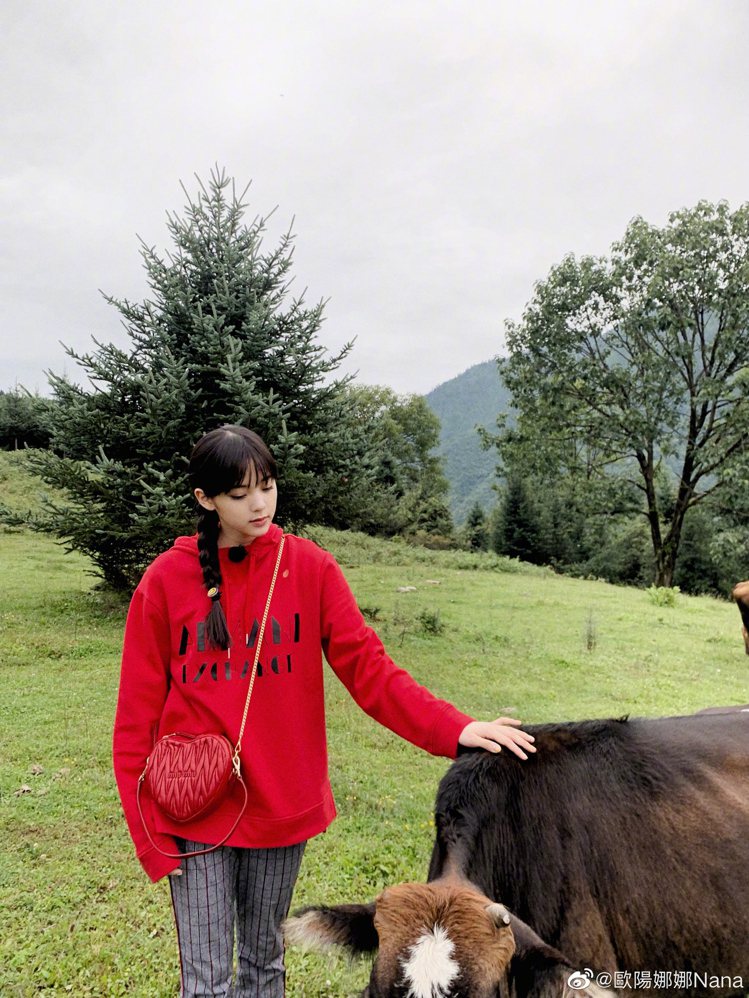 歐陽娜娜穿上Armani Exchange秋冬系列紅色連帽Logo上衣，搭配灰色格紋長褲，展現她年紀該有的青春俏皮。圖／摘自微博