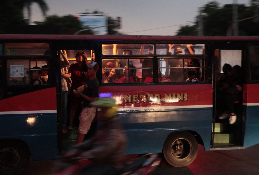 雅加達4日停電時，民眾在漆黑的馬路上搭公車。（美聯社）