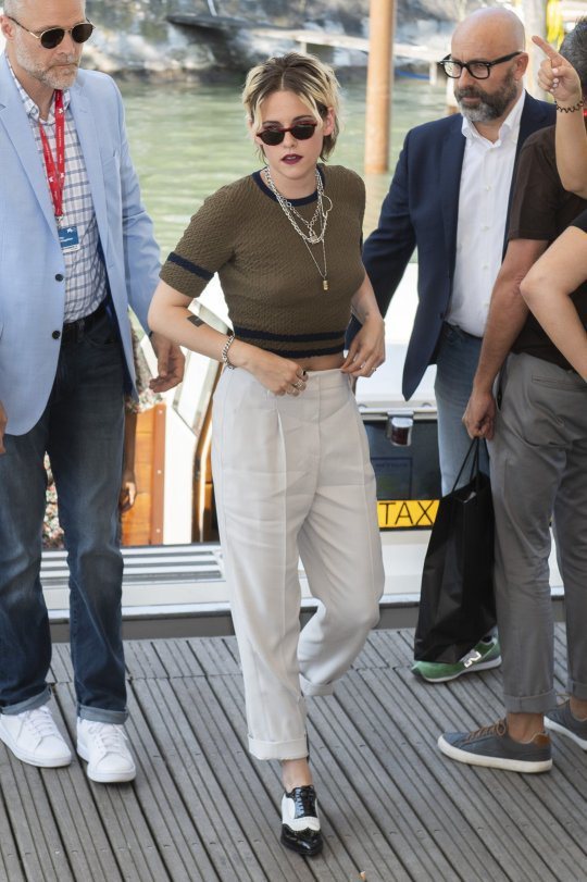 克莉絲汀史都華以香奈兒軍綠色針織上衣配白色老爺褲，展現出她最擅長詮釋的中性時尚感。(美聯社)