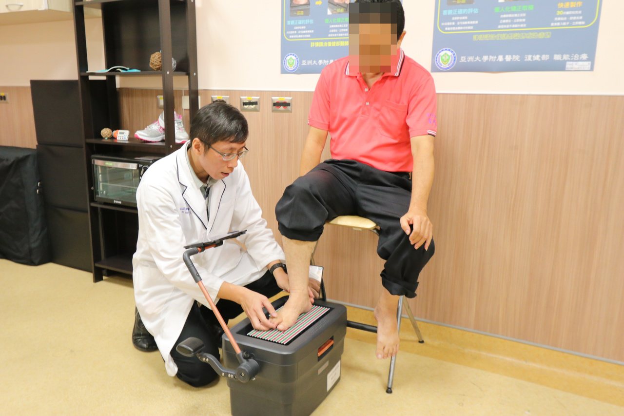 亞洲大學附屬醫院職能治療師施益湋替患者量測足底壓力，以最佳的足弓支撐曲面製作成客製化足墊。圖／亞洲大學附屬醫院