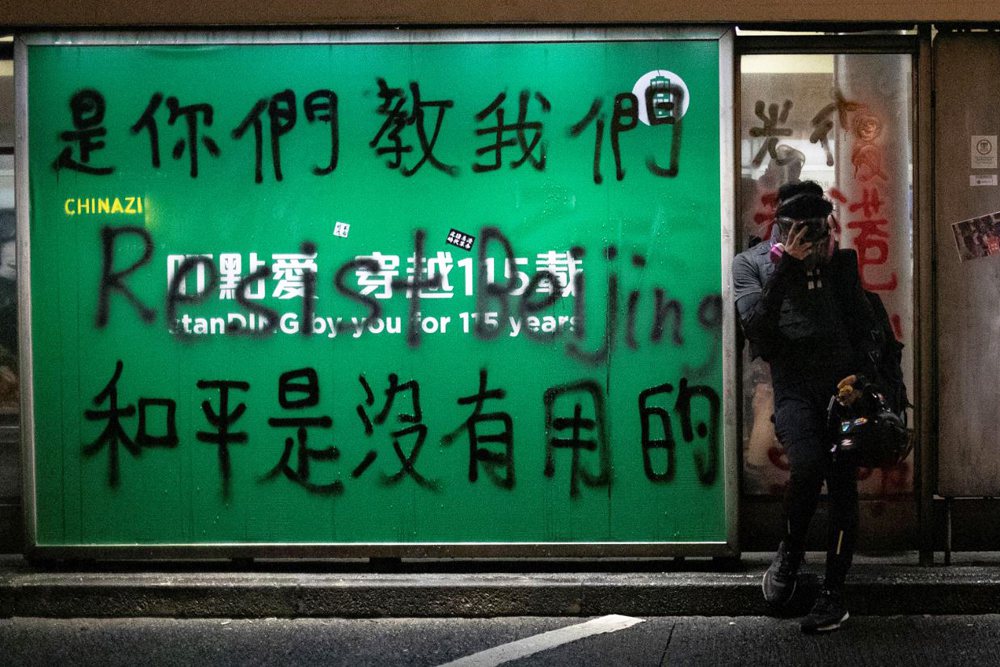 有示威者在香港街頭塗鴉，寫上「是你們教我們，和平是沒有用的」。 圖／路透社