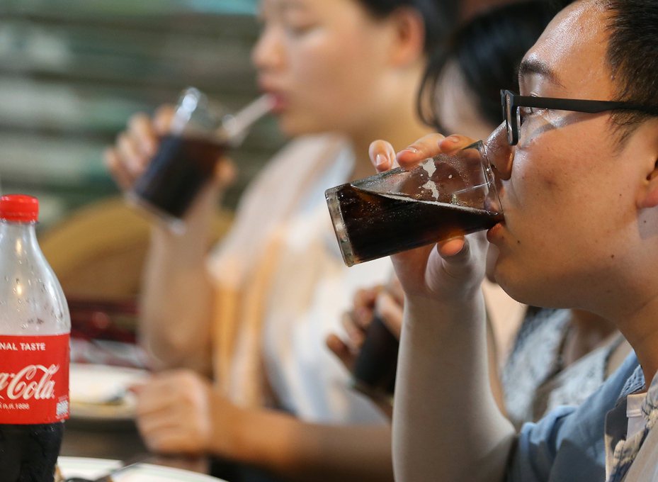 新近研究顯示，較矮的人糖尿病風險較高。圖為泰國曼谷小吃攤客人正在喝含糖飲料。歐新社