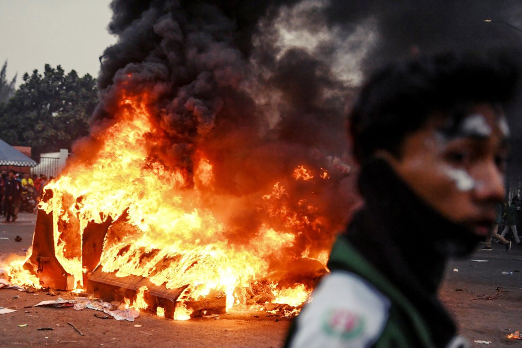雅加達街頭上，示威者與警察的互動越趨緊張，圖為路上被焚燒的車輛。 圖／路透社