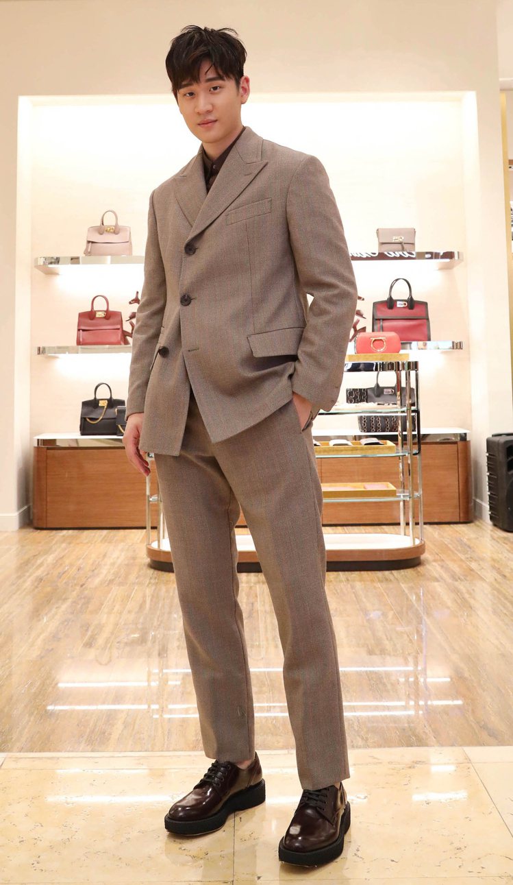 周興哲穿灰色成套西裝、咖啡色襯衫，價格未定，TUXEDO咖啡紅牛皮皮鞋，26,900元。圖／Salvatore Ferragamo提供