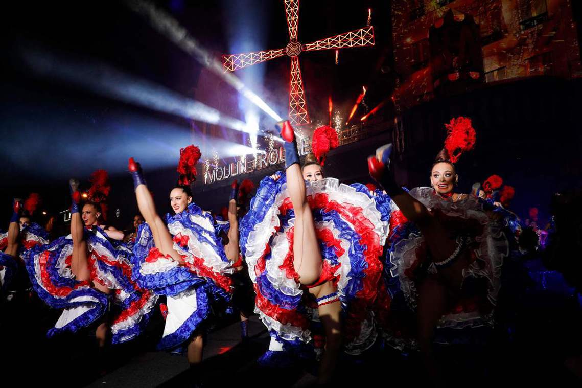 10月6日，舞者在紅磨坊最具象徵性的紅風車前跳著康康舞，慶祝成立130周年。 圖...