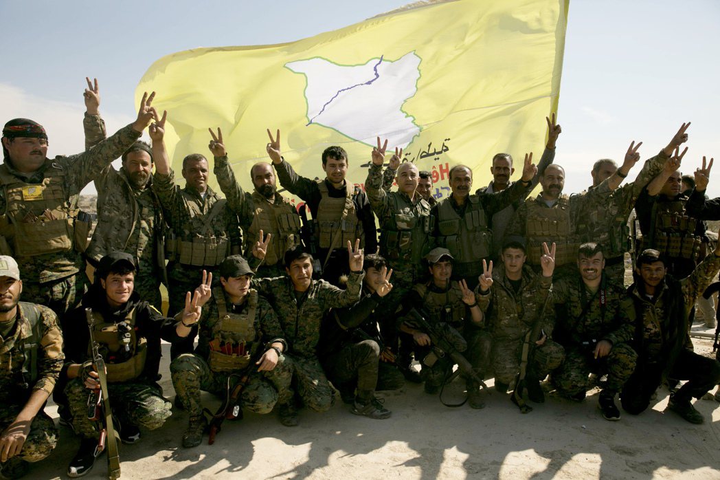 庫德族武裝組織敘利亞民主軍今年3月23日擊潰IS後開心合照慶祝。 （美聯社）