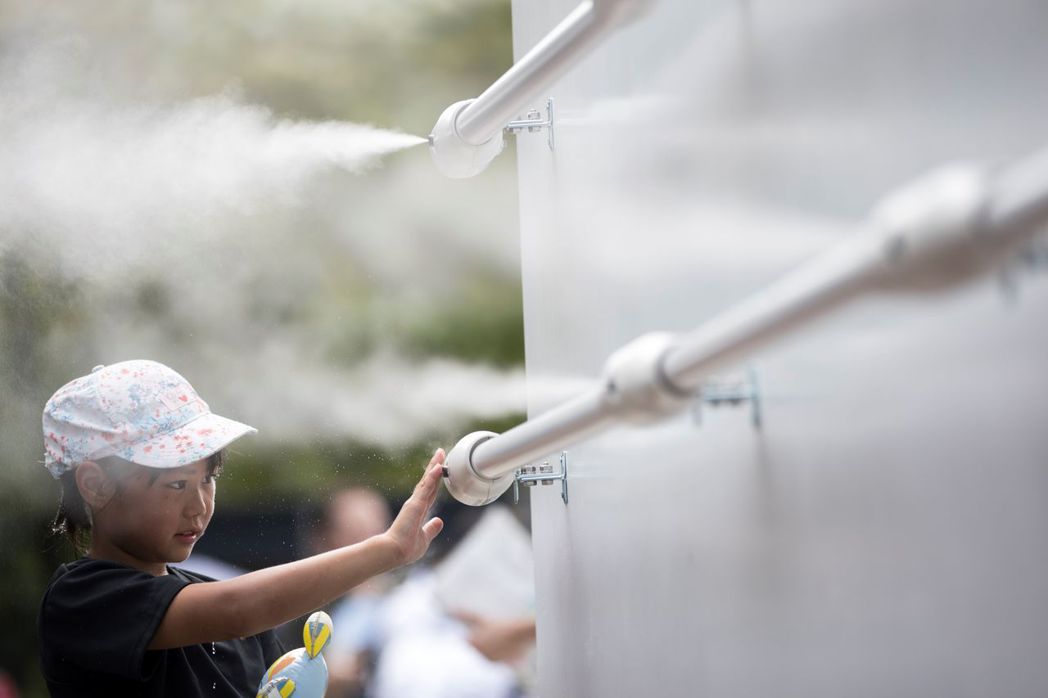 日本奧運主辦單位設置水霧站，希望緩解酷熱。 （法新社）