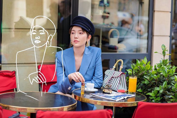 郭雪芙在巴黎咖啡館浪漫街拍，桌上是DELVAUX的Brillant系列條紋包款。...
