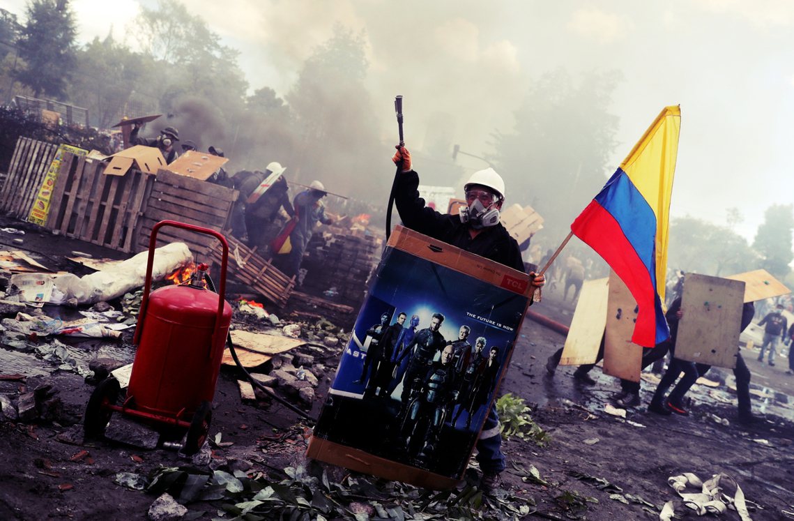 厄瓜多危機，在國家自爆前「奇蹟和解」。圖為憤怒的示威者，扛著瓦斯桶衝上前線——攝...