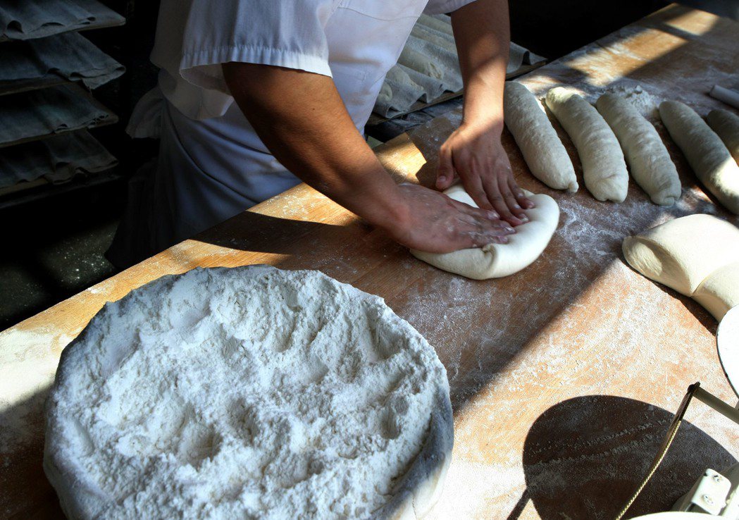 一名麵包師正在揉麵製作長棍麵包。 （法新社）