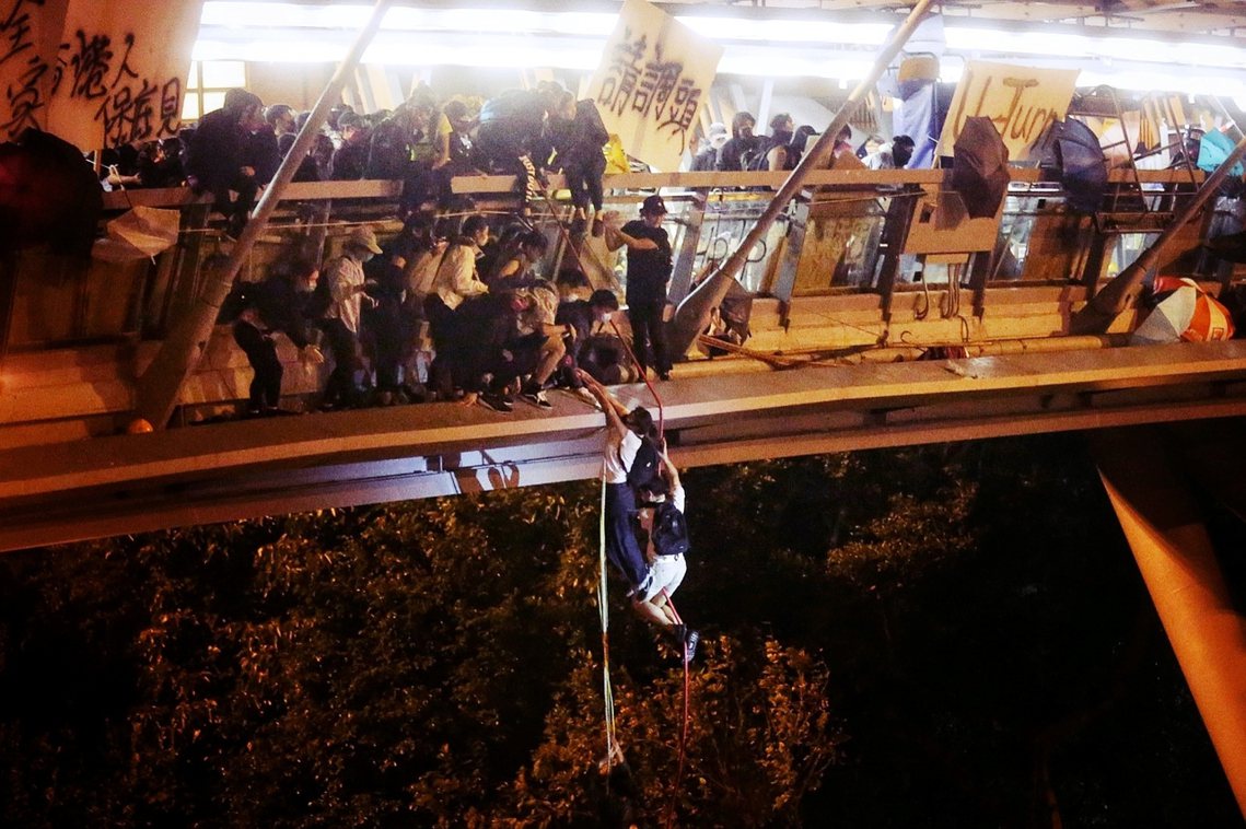 「命懸一線。」18日晚，受困香港理大校園的部分示威者，透過簡易繩索，試圖悄悄突破...
