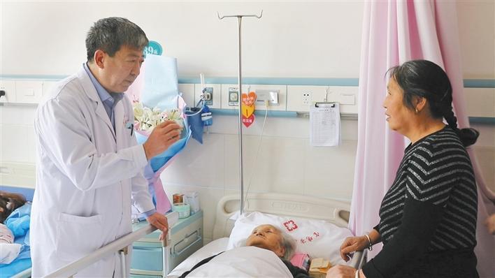 許向東（左）向病人家屬講述治療情況。圖取自陝西日報