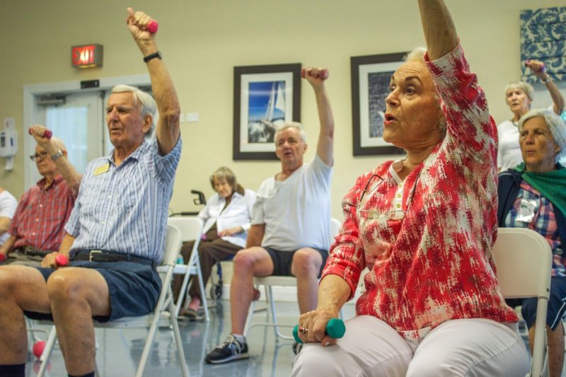 圖為美國佛州卡特勒灣一家養老院內，退休銀髮族拿著啞鈴運動的畫面。 圖／法新社提供