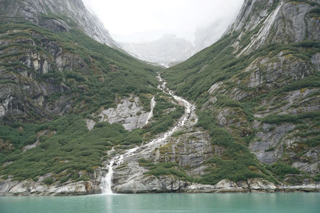 峽灣兩旁有涓涓細緻的瀑布，從高山上層疊而下，濺入清澈的冰河裡。